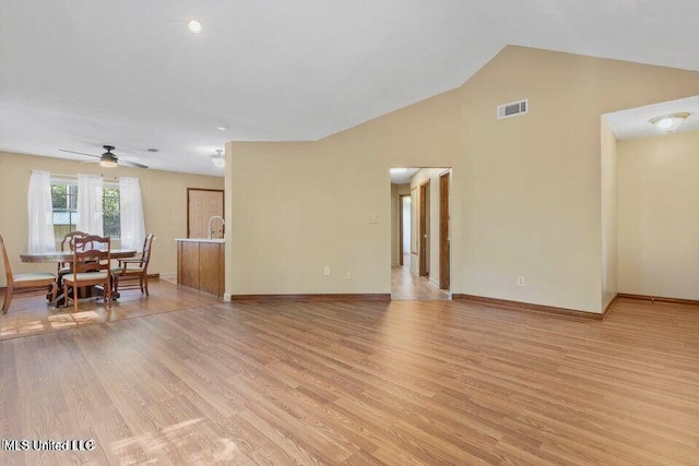 living area featuring light wood-style floors, baseboards, and visible vents