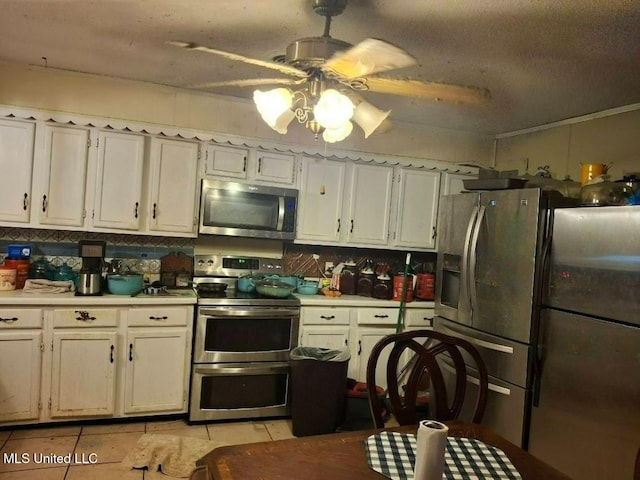 kitchen featuring backsplash, stainless steel appliances, light tile patterned flooring, light countertops, and ceiling fan