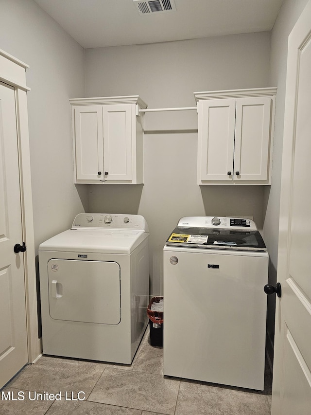 laundry area with visible vents, washer and clothes dryer, and cabinet space