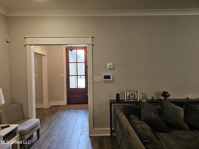 entryway featuring ornamental molding, wood finished floors, and baseboards