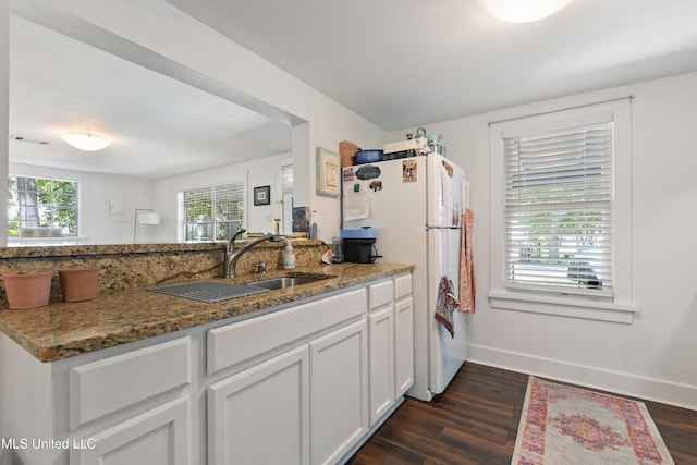 kitchen featuring sink, dark wood-type flooring, dark stone countertops, and white cabinetry