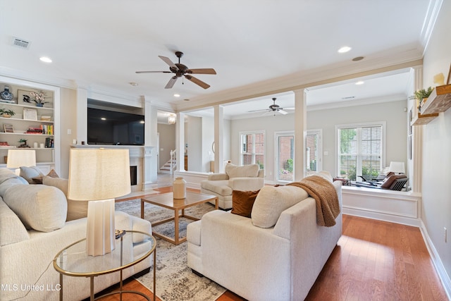 6507 Shenandoah Ln, Olive Branch, MS 38654 - living area featuring visible vents, crown molding, a fireplace with flush hearth, wood finished floors, and a ceiling fan