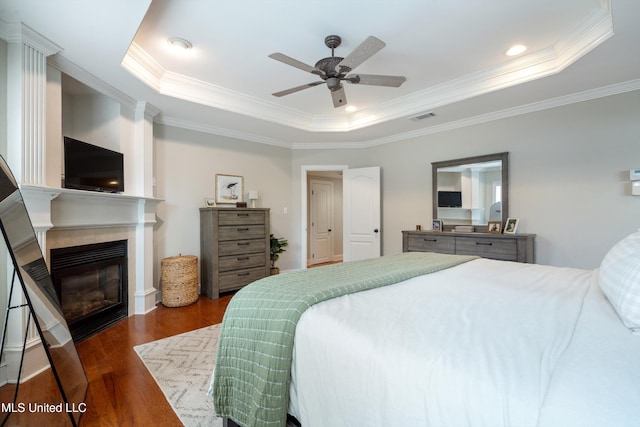 6507 Shenandoah Ln, Olive Branch, MS 38654 - bedroom featuring visible vents, ornamental molding, a glass covered fireplace, wood finished floors, and a tray ceiling