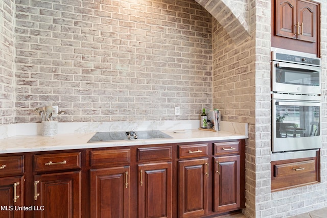 6507 Shenandoah Ln, Olive Branch, MS 38654 - kitchen featuring light countertops, brick wall, double oven, and black electric stovetop