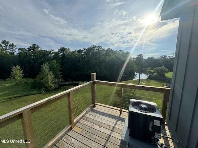 wooden deck featuring a lawn, a water view, and central AC unit