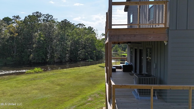 view of yard with a deck with water view and central AC