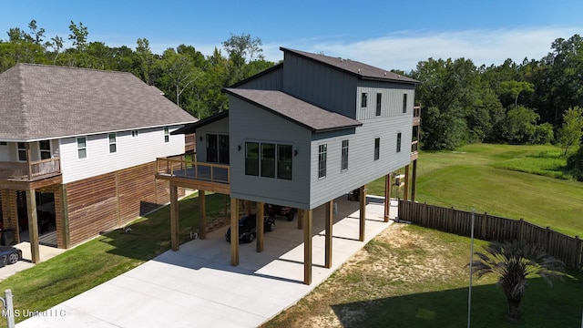 back of property featuring a yard, a balcony, and a carport