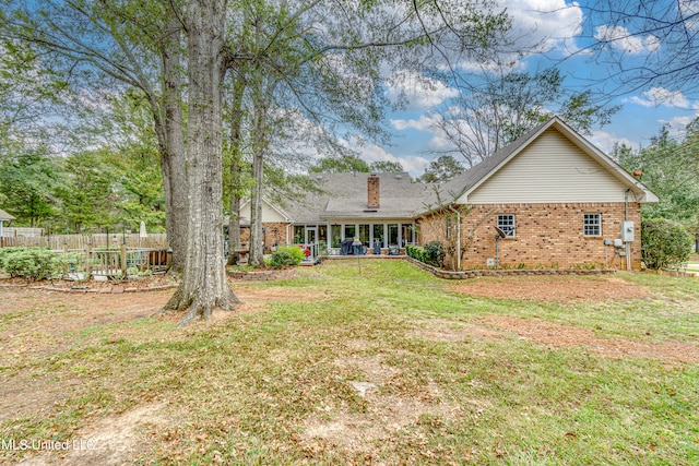 rear view of property featuring a yard