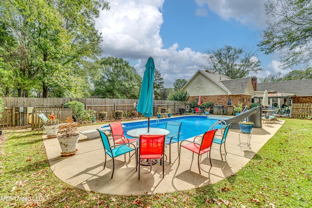 view of pool with a patio area and a lawn