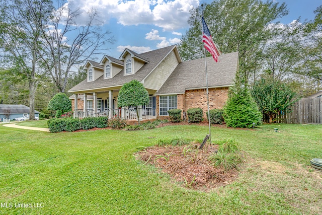 cape cod house with a front lawn and covered porch