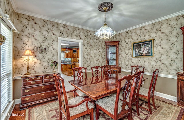 dining room featuring ornamental molding, a notable chandelier, and light hardwood / wood-style floors