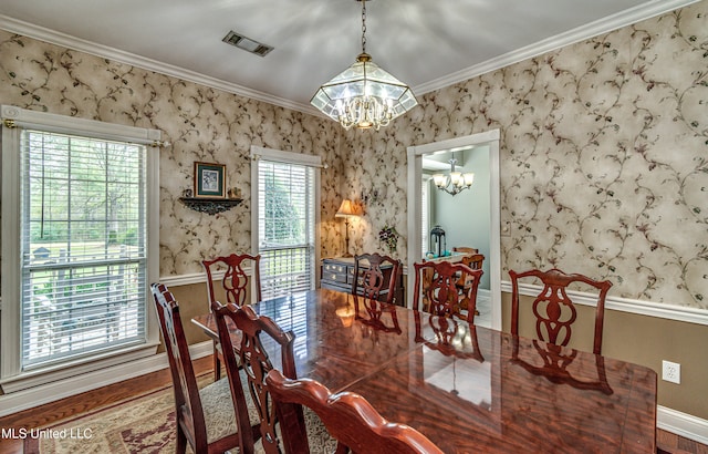 dining room featuring hardwood / wood-style floors, an inviting chandelier, and ornamental molding