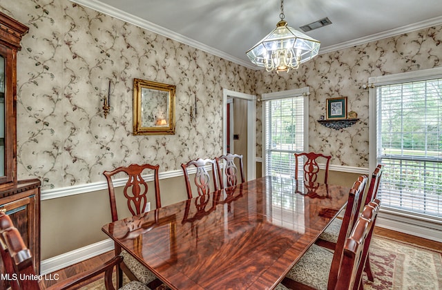 dining room featuring plenty of natural light, wood-type flooring, crown molding, and an inviting chandelier