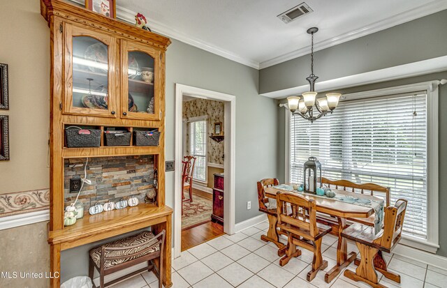 tiled dining space with an inviting chandelier and ornamental molding