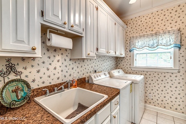 laundry area featuring cabinets, sink, ornamental molding, light tile patterned floors, and washing machine and clothes dryer