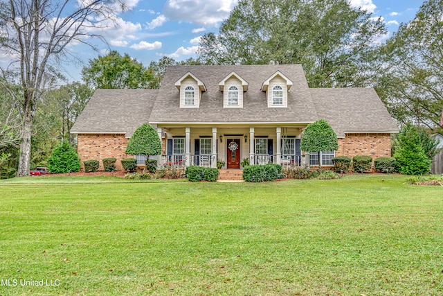 new england style home with covered porch and a front yard