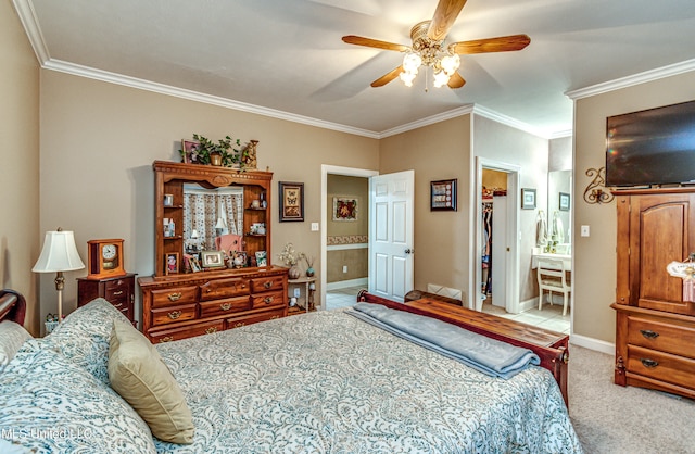 carpeted bedroom with a spacious closet, ceiling fan, ensuite bath, and crown molding