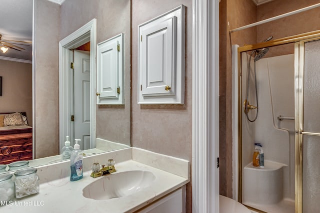 bathroom with ornamental molding, vanity, ceiling fan, and a shower with door