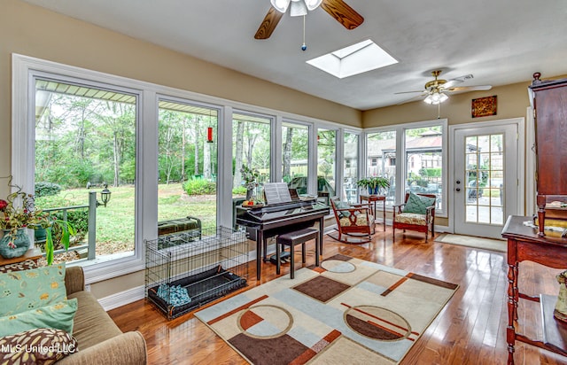 sunroom / solarium featuring a wealth of natural light, ceiling fan, and a skylight