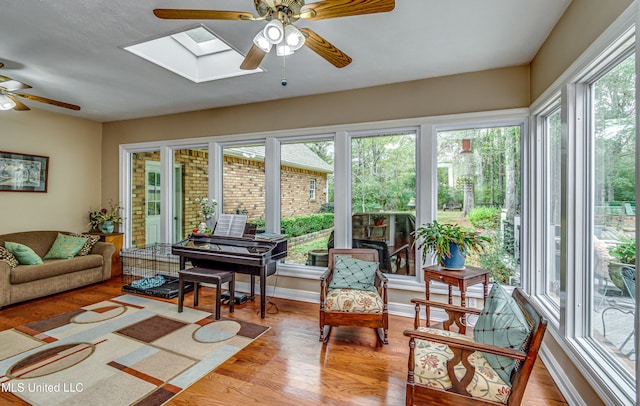 sunroom featuring a skylight, a wealth of natural light, and ceiling fan