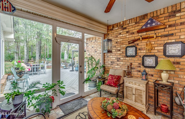 entryway featuring ceiling fan and brick wall