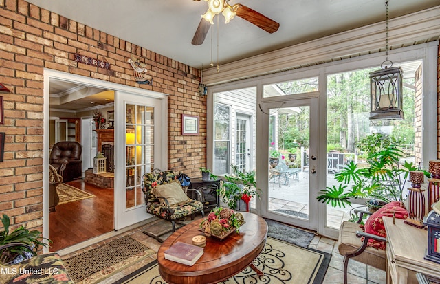 sunroom / solarium featuring a wood stove, french doors, and ceiling fan