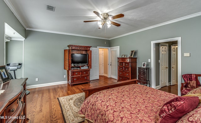 bedroom with dark hardwood / wood-style flooring, ceiling fan, and crown molding