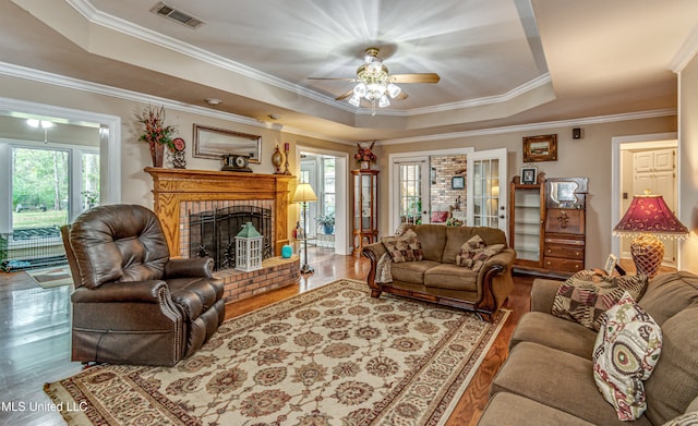 living room with hardwood / wood-style floors, a wealth of natural light, and a raised ceiling