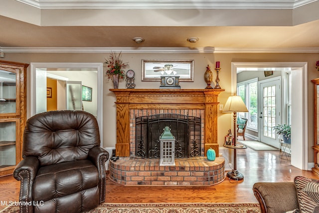 sitting room with a brick fireplace, french doors, light hardwood / wood-style floors, and ornamental molding