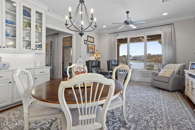 dining area featuring a water view, a ceiling fan, and crown molding