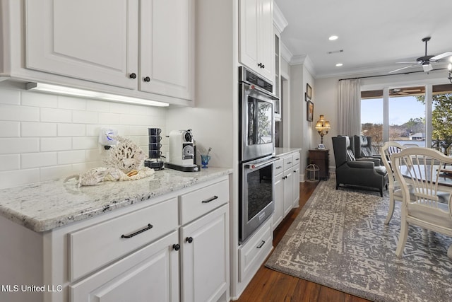 kitchen featuring open floor plan, stainless steel double oven, and white cabinets