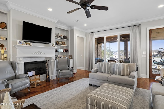 living area with plenty of natural light, built in features, and crown molding