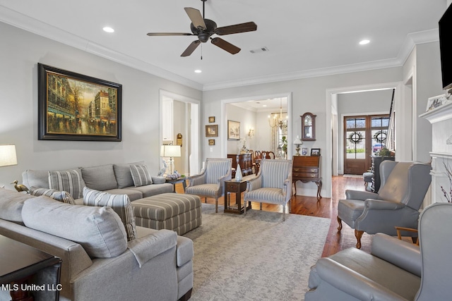 living area with ornamental molding, recessed lighting, visible vents, and wood finished floors