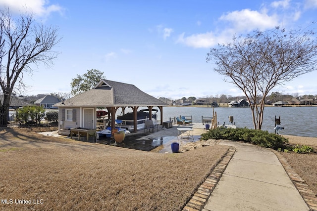 dock area with a water view, a lawn, and a gazebo