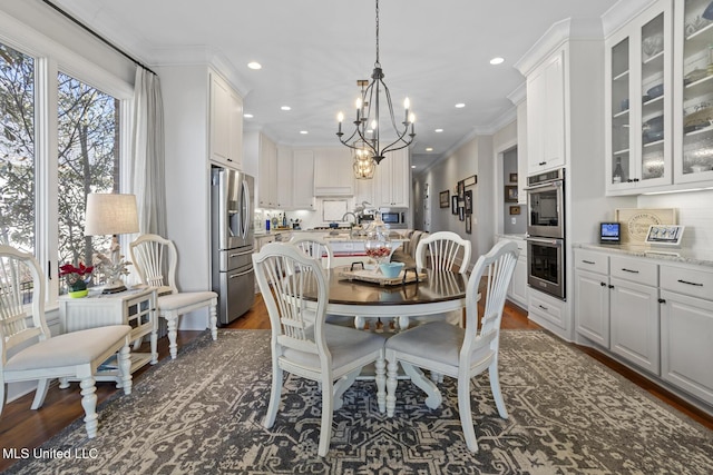 dining area with crown molding, a chandelier, dark wood-type flooring, and recessed lighting