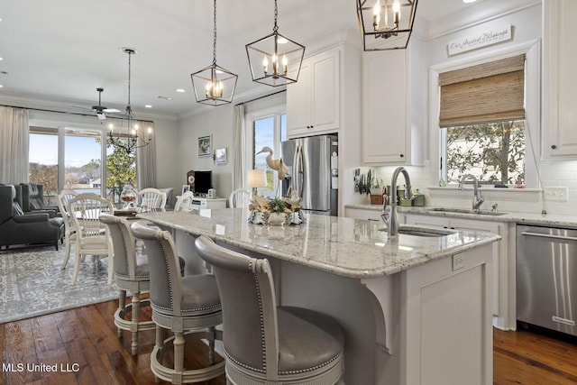 kitchen with stainless steel appliances, a breakfast bar area, white cabinets, and a center island