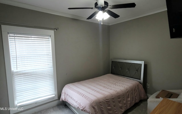 bedroom featuring ornamental molding, multiple windows, and a ceiling fan