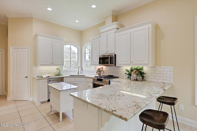 407 Belle Pointe Ln, Madison, MS 39110 - kitchen with stainless steel appliances, a peninsula, a sink, light stone countertops, and a breakfast bar