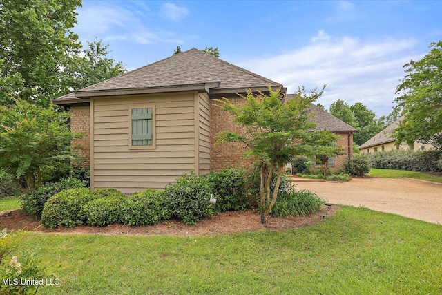 407 Belle Pointe Ln, Madison, MS 39110 - view of side of property featuring a yard, roof with shingles, brick siding, and driveway