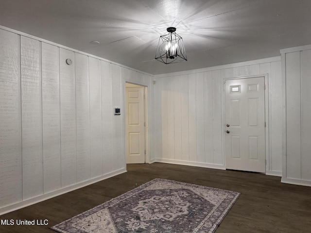 foyer with an inviting chandelier and dark wood-type flooring