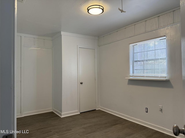 unfurnished bedroom featuring dark wood-type flooring and a closet