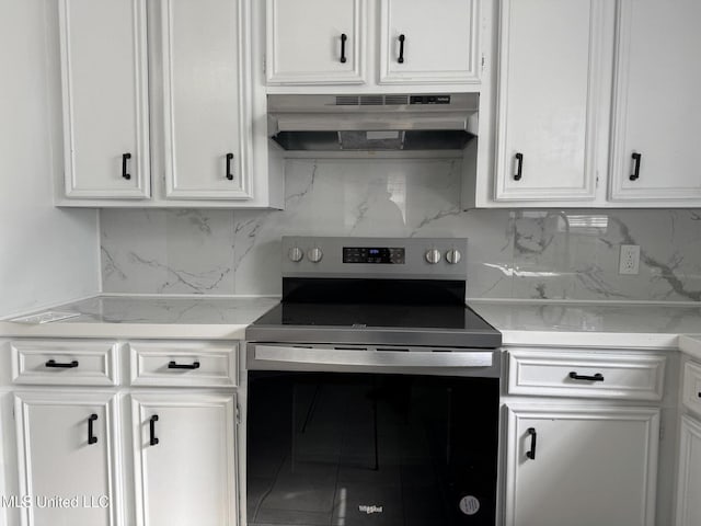 kitchen with electric stove, backsplash, and white cabinets