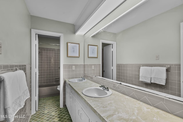 bathroom with tile walls, vanity, and toilet