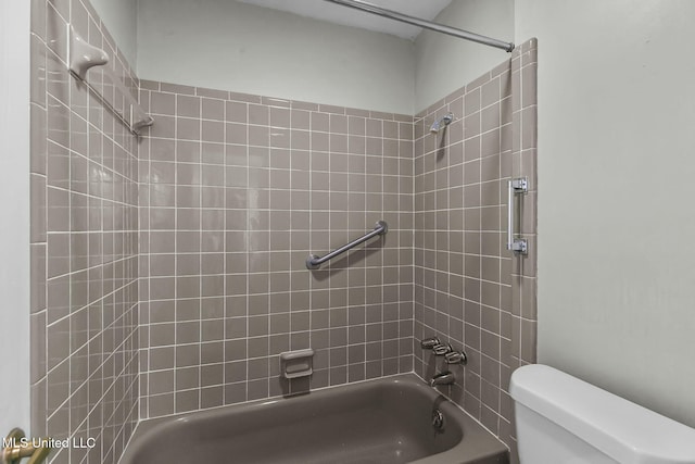 bathroom featuring tiled shower / bath combo and toilet