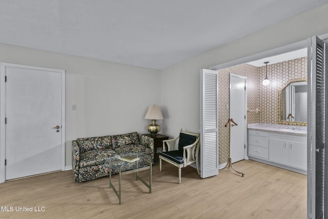 living area with light wood-type flooring and sink