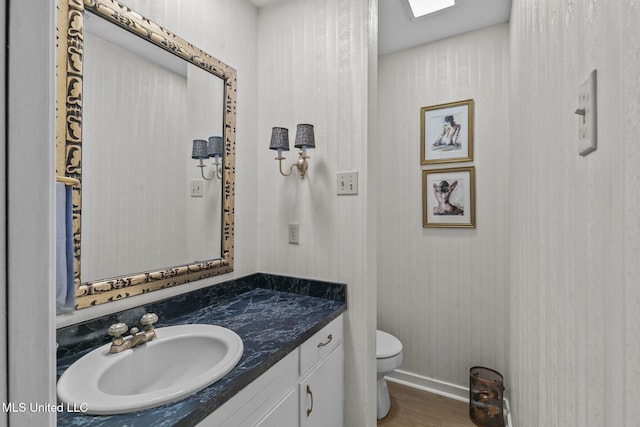 bathroom featuring hardwood / wood-style flooring, vanity, and toilet