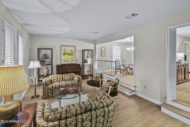 living room with light hardwood / wood-style flooring and an inviting chandelier