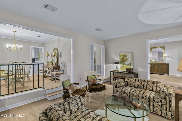 living room with light hardwood / wood-style flooring and a notable chandelier