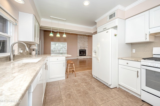 kitchen featuring white appliances, white cabinetry, decorative light fixtures, and sink