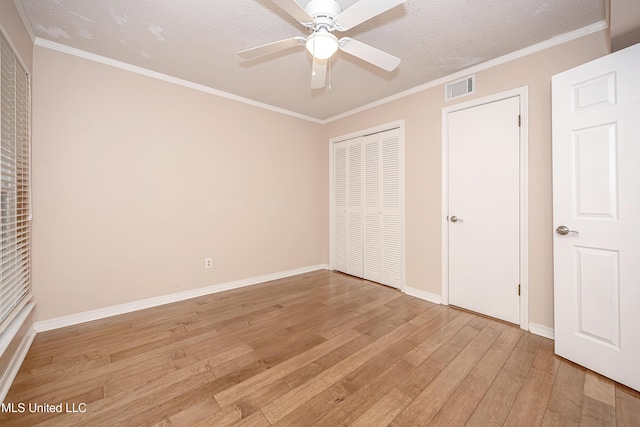 unfurnished bedroom featuring crown molding, a textured ceiling, ceiling fan, and light hardwood / wood-style flooring